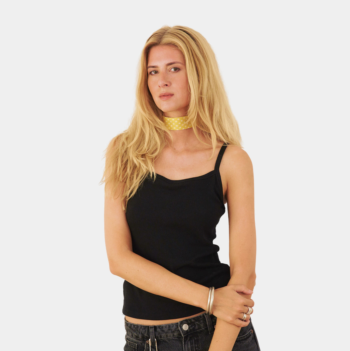 Model wearing a bright yellow silk choker with a repeating white star pattern