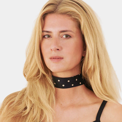 model wearing a black silk choker with repeating white polka dots