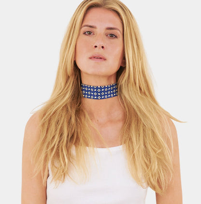 model wearing a blue silk choker with a repeating geometric pattern of diamonds and ovals