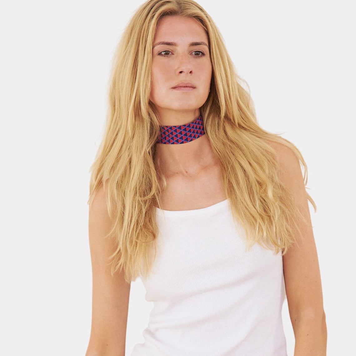 Model wearing a deep navy and red silk choker with a geometric triangle pattern