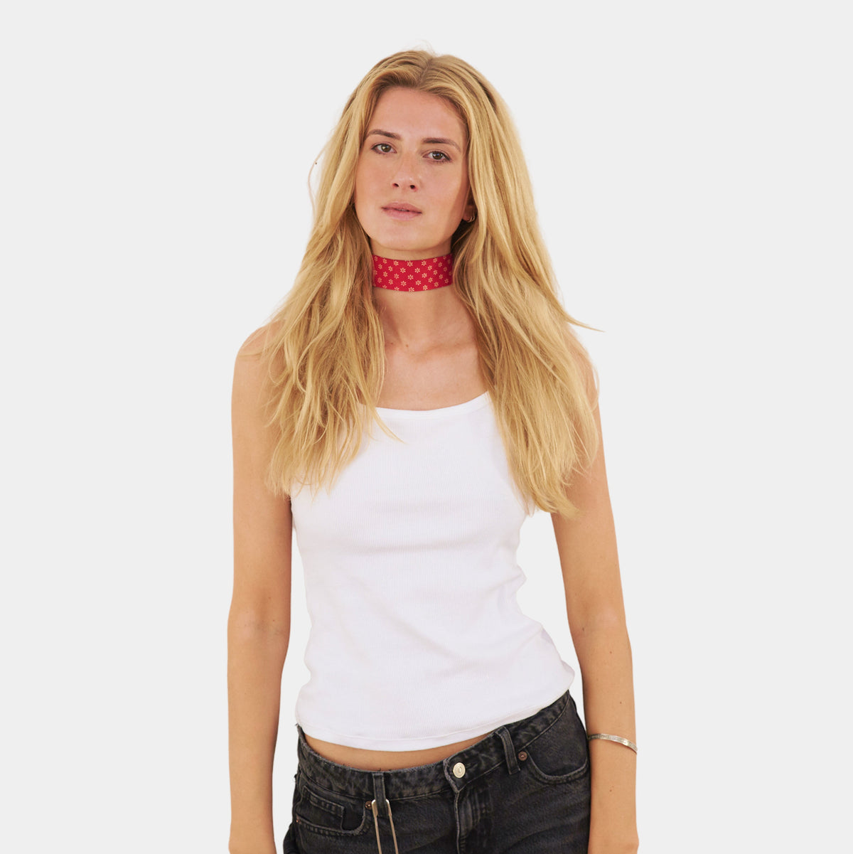model wearing a red silk choker with a repeating white floral pattern