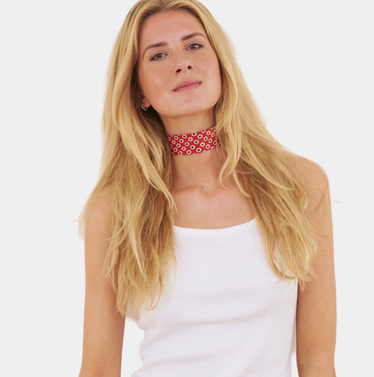 Model wearing a red silk choker with oval pattern