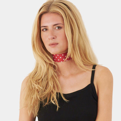 Model wearing a red silk choker with a repeating white star pattern