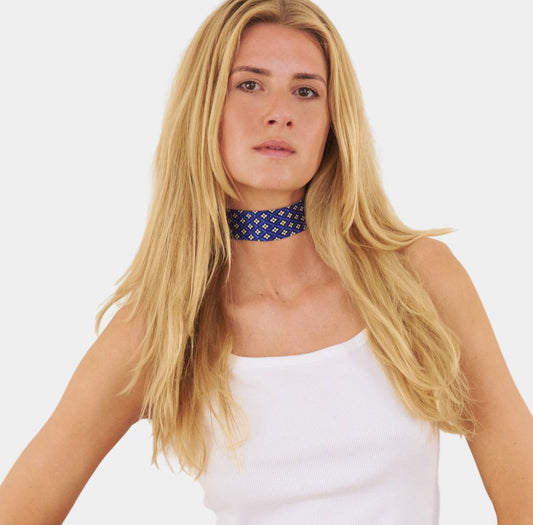 model wearing a sapphire blue silk choker with a repeating floral diamond pattern