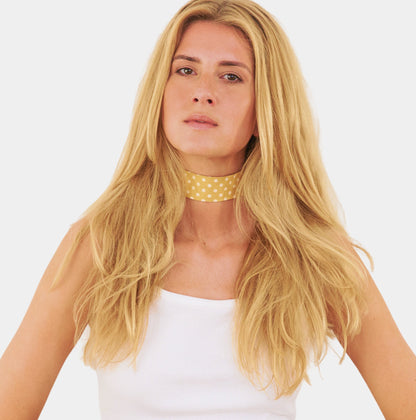 model wearing a yellow silk choker with repeating white polka dots