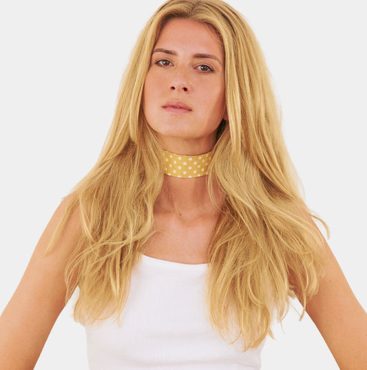 model wearing a yellow silk choker with repeating white polka dots