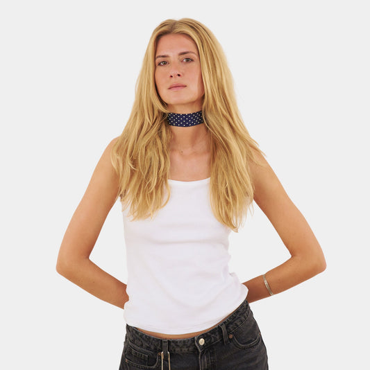 model wearing a navy blue silk choker with a repeating white dot pattern