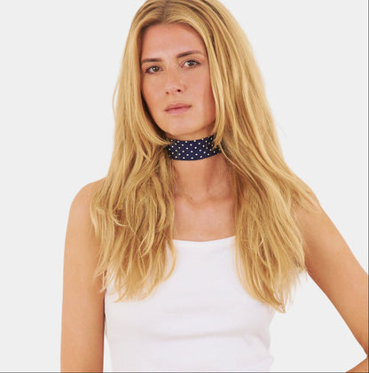 model wearing a navy blue silk choker with a repeating white dot pattern